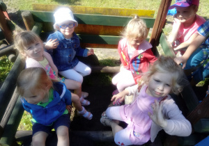 Dzieci siedzą w drewnianym pociągu